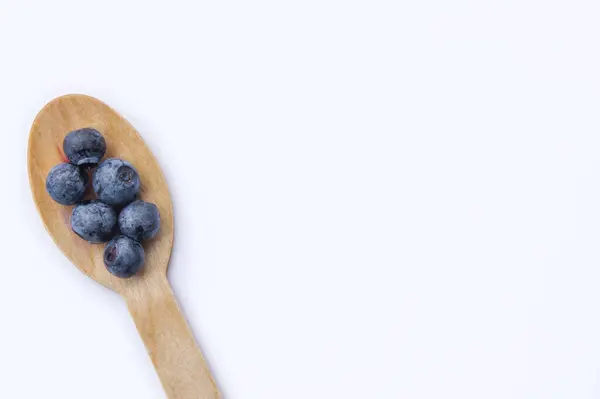 Recycled spoon and juicy, fresh blueberries on color table — Stock Photo, Image