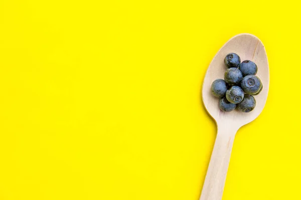 Recycled spoon and juicy, fresh blueberries on color table — Stock Photo, Image