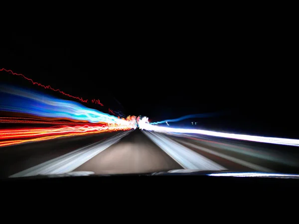 Gece karayolu neon ışıkları şehrin yakınlarında uzun süre açık