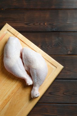 Tahtada taze çiğ tavuk bacağı. 