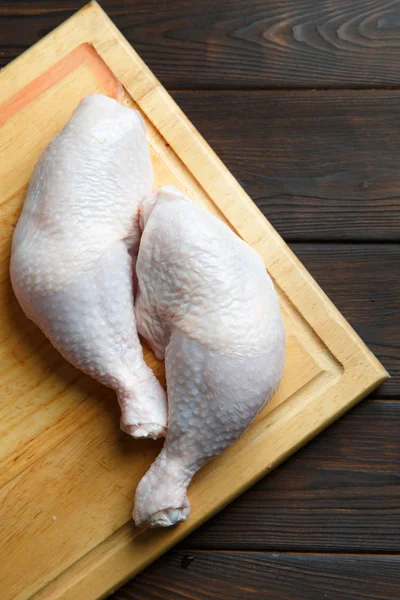 Tahtada taze çiğ tavuk bacağı.