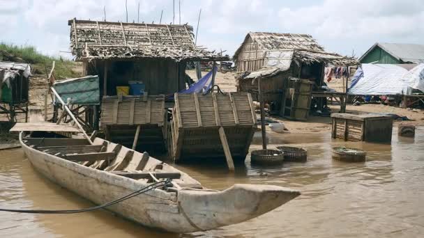 Rumah-rumah nelayan kecil dengan kano dugout, peti ikan dan perahu kayu di tepi sungai — Stok Video