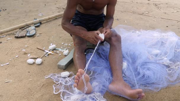 Pescatore che utilizza un ago di rete da pesca per riparare una rete — Video Stock