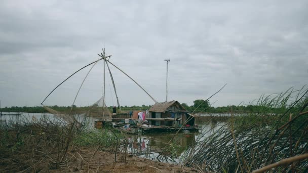 Vista del río al pescador usando una red de mano para sacar peces capturados de una red de pesca china — Vídeos de Stock