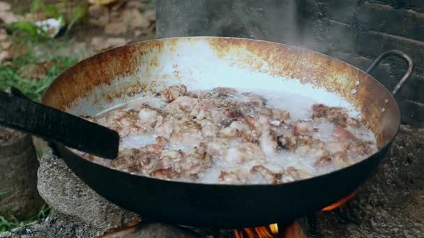 오픈 화재 요리 냄비에 돼지고기 껍질의 튀김된 조각에 근접 — 비디오