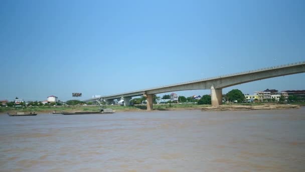 Aak trekken achter een grote hoop van bamboe stokken in een rivier — Stockvideo