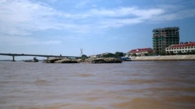 bir mavna arka görünümü bir nehir aşağı bambu direkleri büyük bir yığın arkasında çekiyor