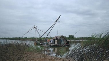 Sudan bir Çin balıkçı ağı kaldırma balıkçı için Riverside görünümü