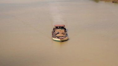 Nehri üzerinde temizletir kum taşıyan bir mavna önden görünümü