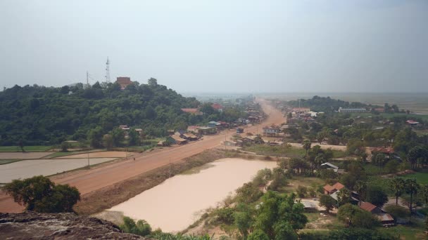 Vista a distancia de la carretera polvorienta del pueblo principal que pasa por una pequeña ciudad — Vídeos de Stock