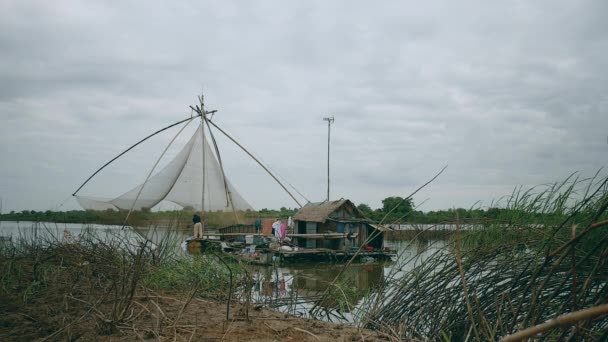 Vista al río al pescador levantando la red de pesca china fuera del agua — Vídeos de Stock