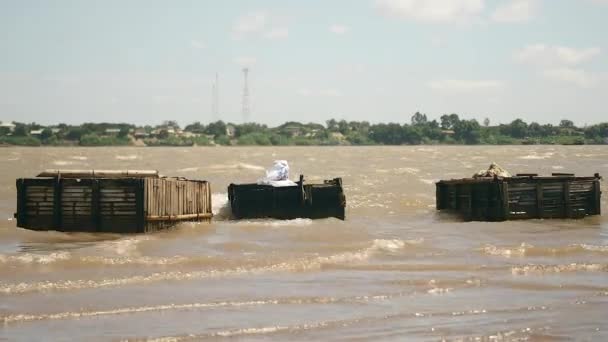 Venti forti e fiume corrente pesante; Onde che colpiscono casse di pesce in legno — Video Stock