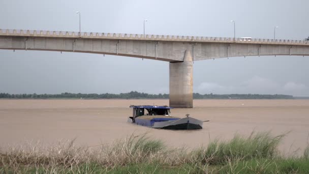Chiatta fluviale caricata di sabbia dragata legata alla riva vicino a un ponte — Video Stock
