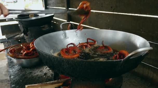 Mujer tomando pequeñas serpientes fritas del wok en una cesta de bambú — Vídeo de stock