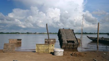 nehir kenarında ahşap balık kasaları ve plastik kaplarda tutulan balık yakalamak