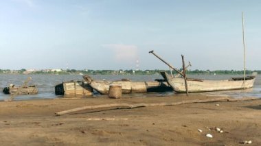 Dugout kano ve ahşap balık kasaları nehrin kenarında bambu sopalarla tutun