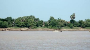 küçük motorlu sığınağı kano bir nehir aşağı bambu direkleri büyük bir yığın arkasında çekerek