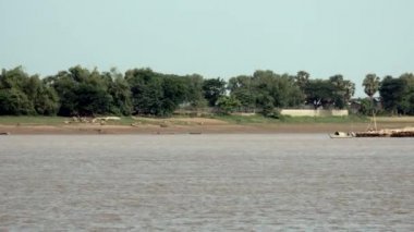 küçük motorlu sığınağı kano bir nehir aşağı bambu direkleri büyük bir yığın arkasında çekerek