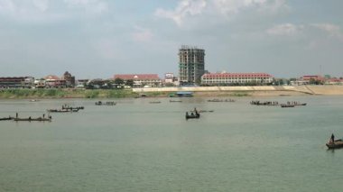 Nehirde balıkçı tekneleri ve bir grup balıkçı sudan büyük bir ağ çekerek