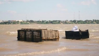 Şiddetli rüzgar ve ağır geçerli nehir; Tahta balık sandıkları isabet dalgalar 