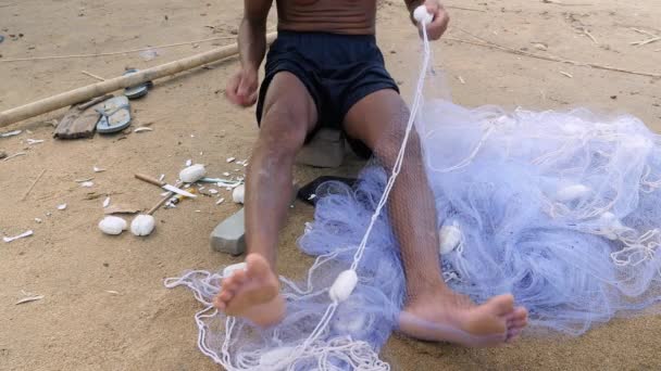 Fisherman using a fishing net needle for mending a net — Stock Footage Fisherman using a fishing net needle for mending a net Royalty Free Stock Footage