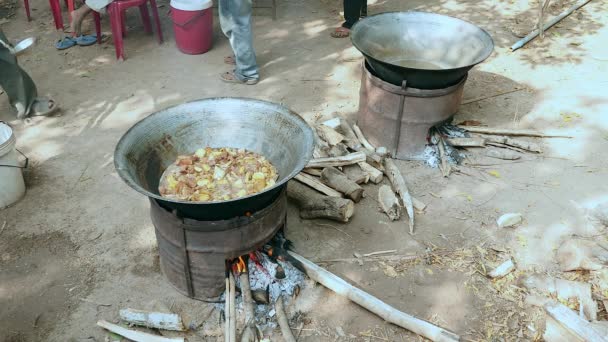 Remover las verduras fritas con cerdo en un wok en una gran estufa de carbón y brasero de leña al aire libre — Vídeo de stock