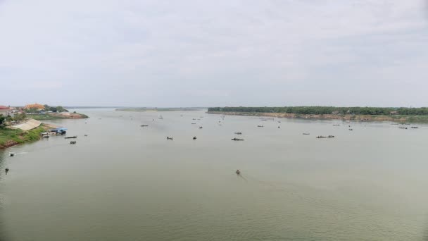 Flodlandskap med spridda fiskebåtar och grupper av fiskare som drar stora nät av vatten — Stockvideo