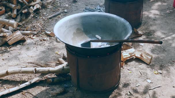 Wokning nedskärningar av fläsk i en wok på en stor träkol och trä brazier spis utomhus — Stockvideo