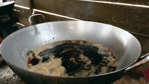 Жінка занурює мертвих змій в киплячу олію для приготування їжі — стокове відео