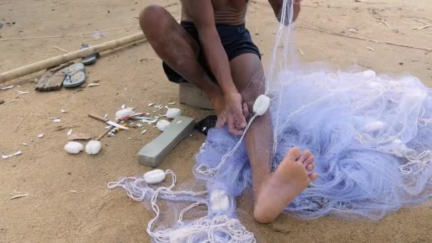 Pescador usando uma agulha de rede de pesca para consertar uma rede — Vídeo de Stock