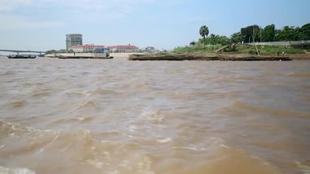 Péniche tirant derrière un grand tas de poteaux de bambou vers le bas d'une rivière — Video