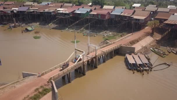 Aerial Static View Motorbikes Crossing Small Bridge Straddles Floating Village — Stock Video