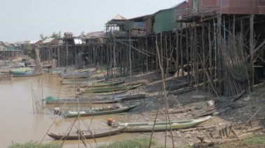 Tonle Sap nehrinin kıyısında alçak su seviyesinde kayıkları olan yüzen bir köy.
