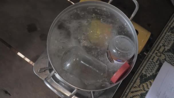 深い鍋の中の基本的なガラス瓶を閉じて10分間沸騰した水に浸かり — ストック動画