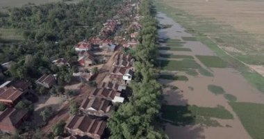 Hava aracı kırsal köy boyunca toprak yola doğru uçuyor.