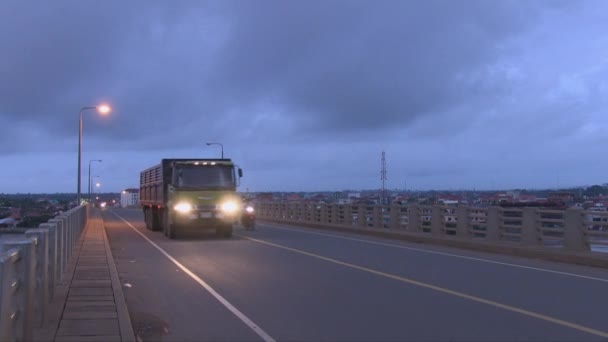 夜間に橋を渡って走行するヘッドライト付きトラックのフロントビュー — ストック動画