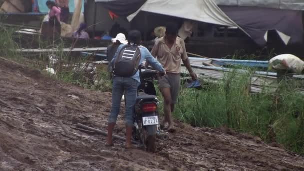 Uomo Spingendo Una Moto Sentiero Fangoso Banchina Sotto Pioggia — Video Stock