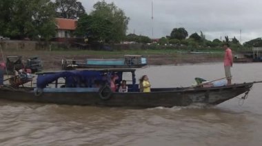 Küçük feribot bulutlu gökyüzünün altında rıhtımdan ayrılıyor