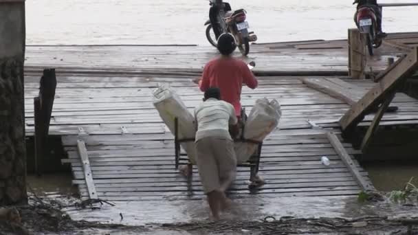 Άνθρωπος Πιέζει Μοτοσικλέτα Φορτωμένο Πάγο Για Βοηθήσει Πάρει Πλοίο Στο — Αρχείο Βίντεο
