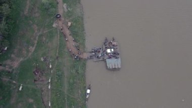Bird eye view of passengers getting out of ferry boat moored at the wooden pier