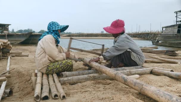 Menutup Pada Dua Wanita Menggergaji Tangkai Bambu Tepi Pasir — Stok Video
