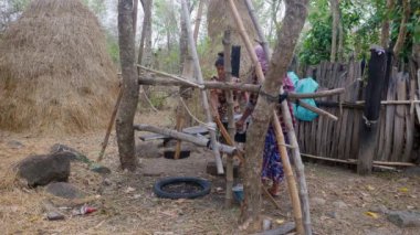 Khmer traditional sugar palm makers. Women carrying a huge wok filled with sweet sap under  the kind of churn made from wood is used  to stir the palm sugar 