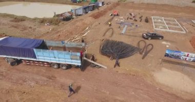 Kamyon römorkundan boşaltılan çelik parmaklıkların drone çekimi. 