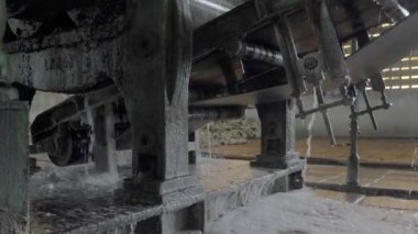 Koagulumun kapağı, kauçuğu ezen ve bastıran bir seri makineyle işleniyor.