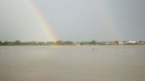 Double rainbow over river with small fishing boat — Stock Video