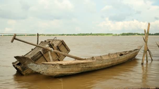 Dugout canoa ao lado de caixa de peixe de madeira detém com postes de bambu na borda do rio (close-up  ) — Vídeo de Stock