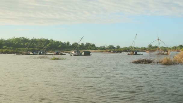 Hausboote mit chinesischen Fischernetzen auf dem Fluss und einem großen Fischernetz, das als Hintergrund aus dem Wasser gehoben wird — Stockvideo