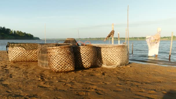 在刮风天用于捕鱼活动在河岸上的竹筐 — 图库视频影像