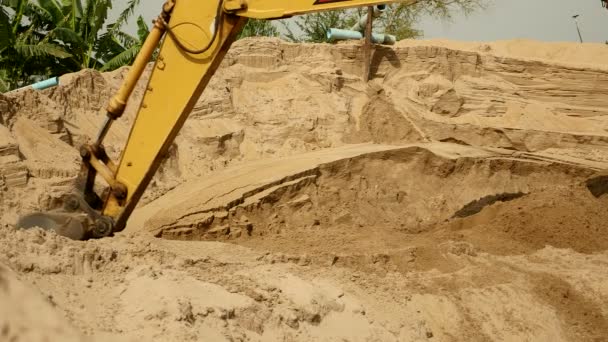 Escavadeira industrial cavando areia vermelha em uma pilha de areia . — Vídeo de Stock