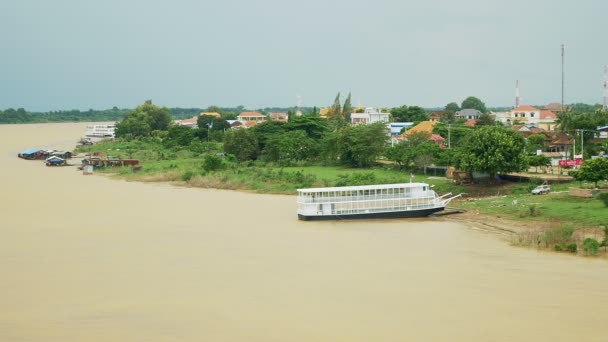 Brückenblick auf die Stadt am Fluss mit Kreuzfahrtschiff und schwimmenden Häusern am Ufer — Stockvideo